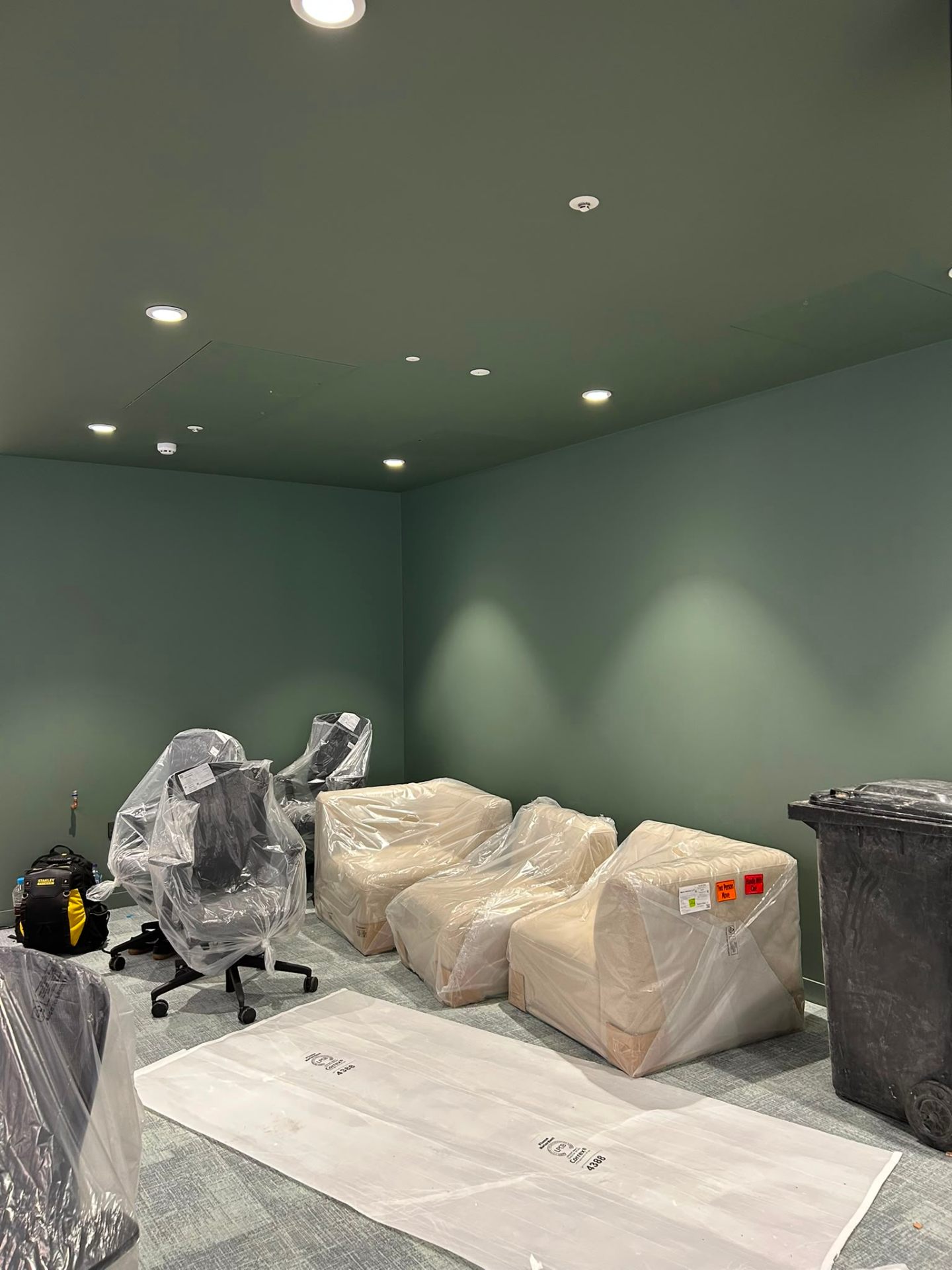 Commercial renovation office lounge with deep sage tones by MOVIR INTERIORS